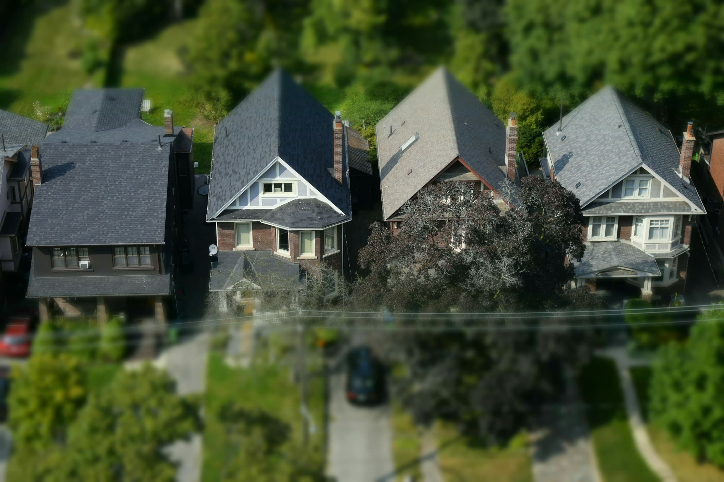 Aerial view of neighboring homes with dark architectural shingle roofs