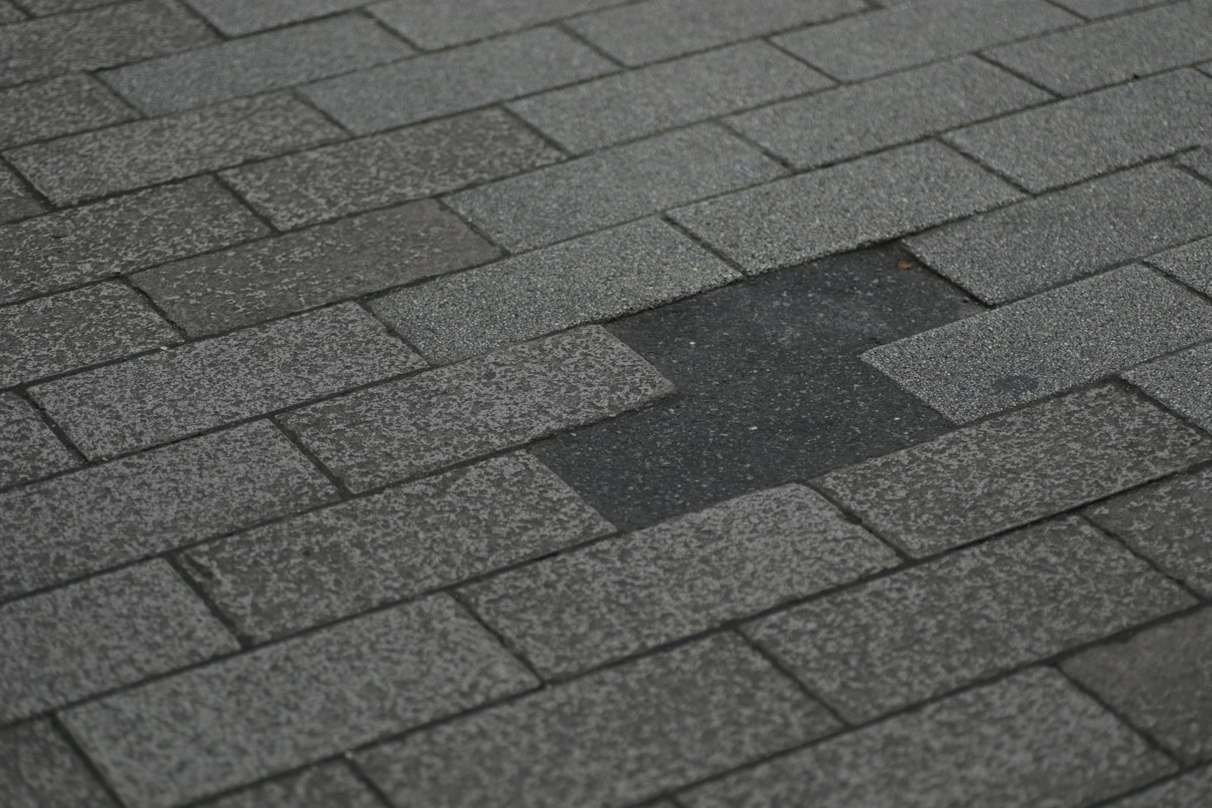 Gray asphalt shingle roof with a patch of missing shingles