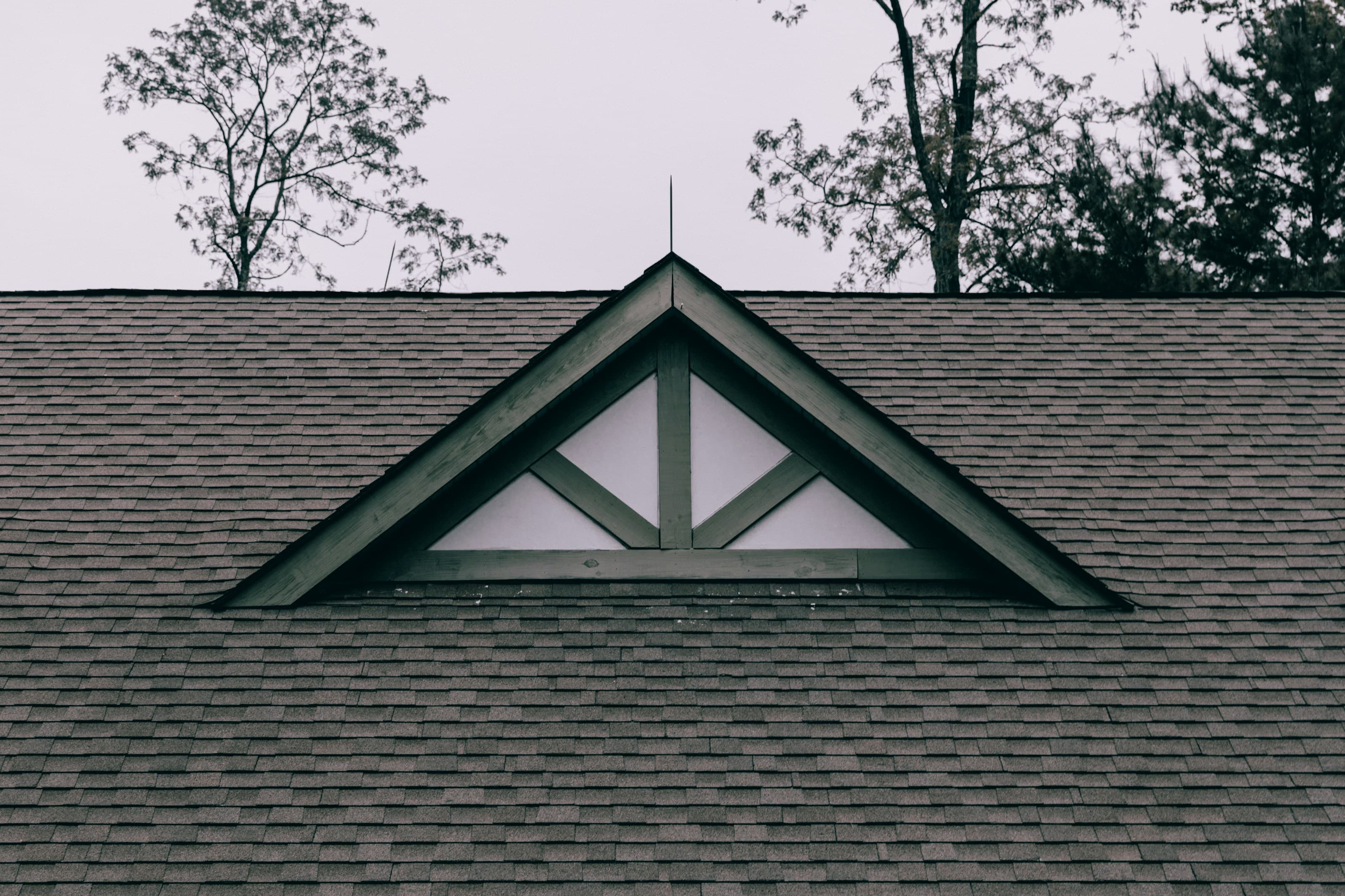 Dimensional asphalt shingles around a gable vent