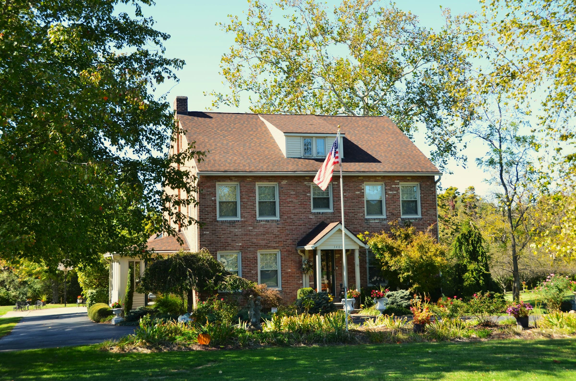 Two-story brick home with an American flag and a dimensional shingle roof